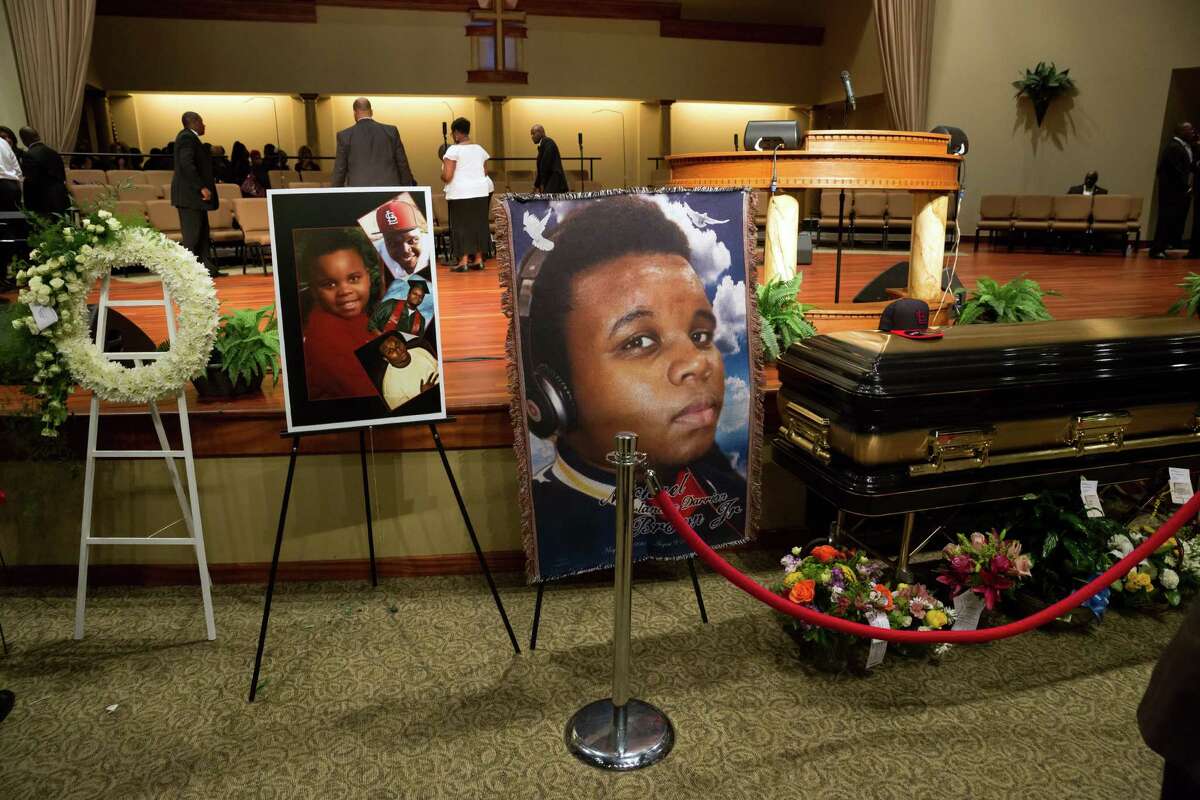 Photos surround the casket of Michael Brown before the start of his funeral at Friendly Temple Missionary Baptist Church in St. Louis, Monday, Aug. 25, 2014. Brown, who is black, was unarmed when he was shot in Ferguson, Mo., Aug. 9 by Officer Darren Wilson, who is white. Protesters took to the streets of the St. Louis suburb night after night, calling for change and drawing national attention to issues surrounding race and policing.