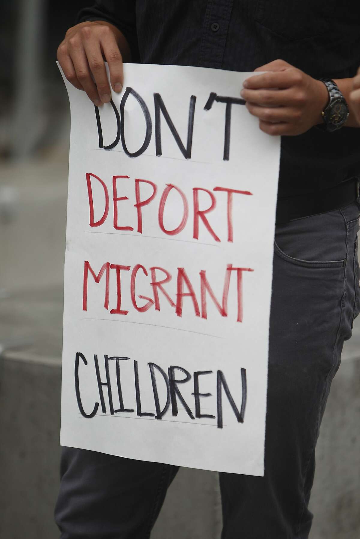 A demonstrator holds a sign during a press conference at the San Francisco Federal Building where immigrant rights groups gathered to demand recognition for children refugees entering the United States on Monday, July 21, 2014 in San Francisco, Calif.