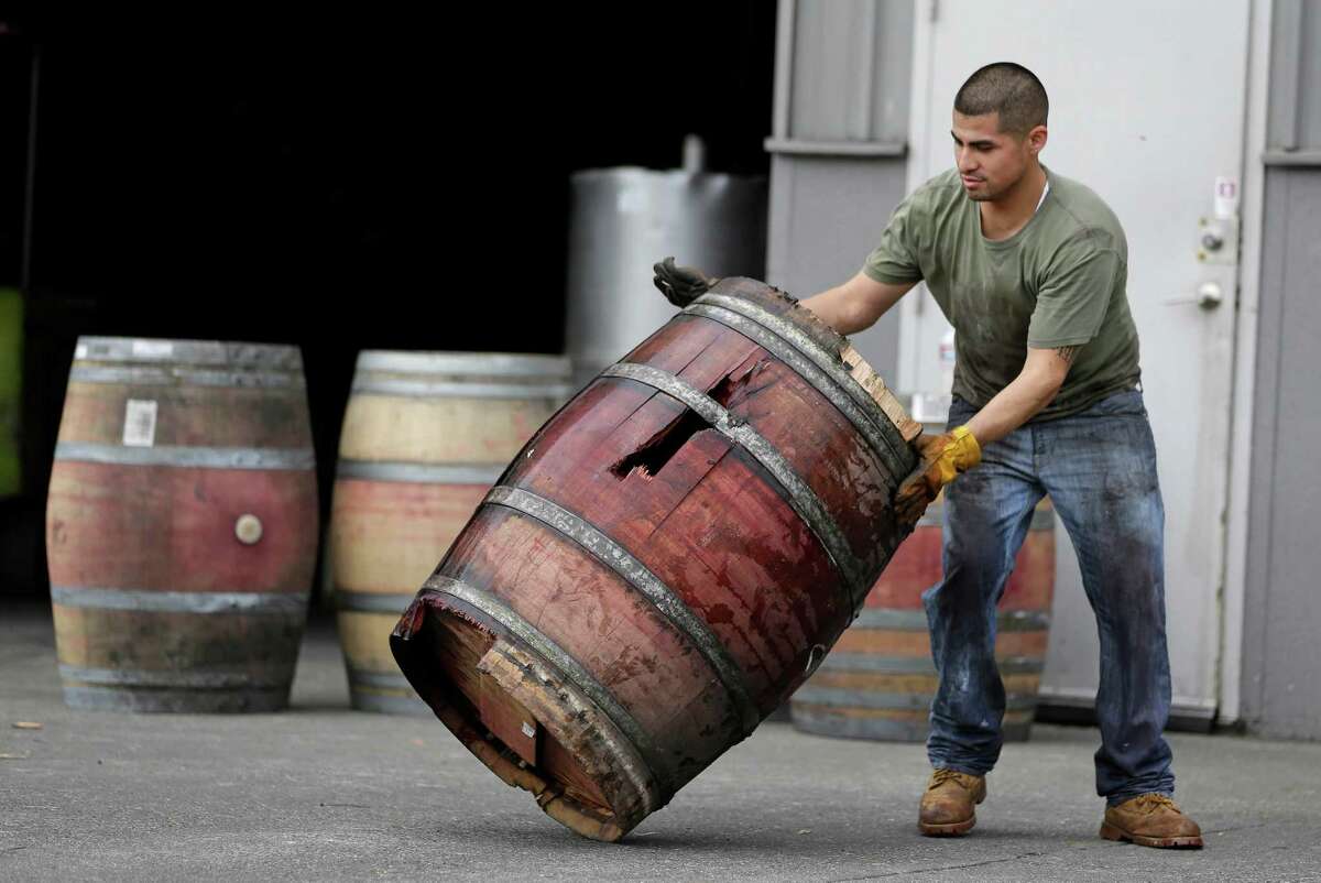 A worker removes an earthquake-damaged wine barrel from Napa Barrel Care Monday, Aug. 25, 2014, in Napa, Calif. A powerful earthquake that struck the heart of California's wine country caught many people sound asleep, sending dressers, mirrors and pictures crashing down around them and toppling wine bottles in vineyards around the region. The magnitude-6.0 quake struck at 3:20 a.m. PDT Sunday near the city of Napa. (AP Photo/Eric Risberg)