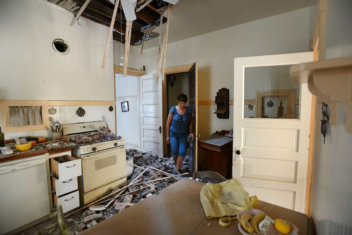 Kelly Darter looking over damage from the chimney that came crashing into the kitchen of her home on the 1600 block of First Street in downtown Napa after Sunday morning's 6.0 quake. "Oh yeah, we've decided, we're going to fix this," said Darter whose family built the home in 1905 after arriving from Prussia and whose 97-year-old grandmother Claire Erks just passed away last September in the next room. August 25, 2014.