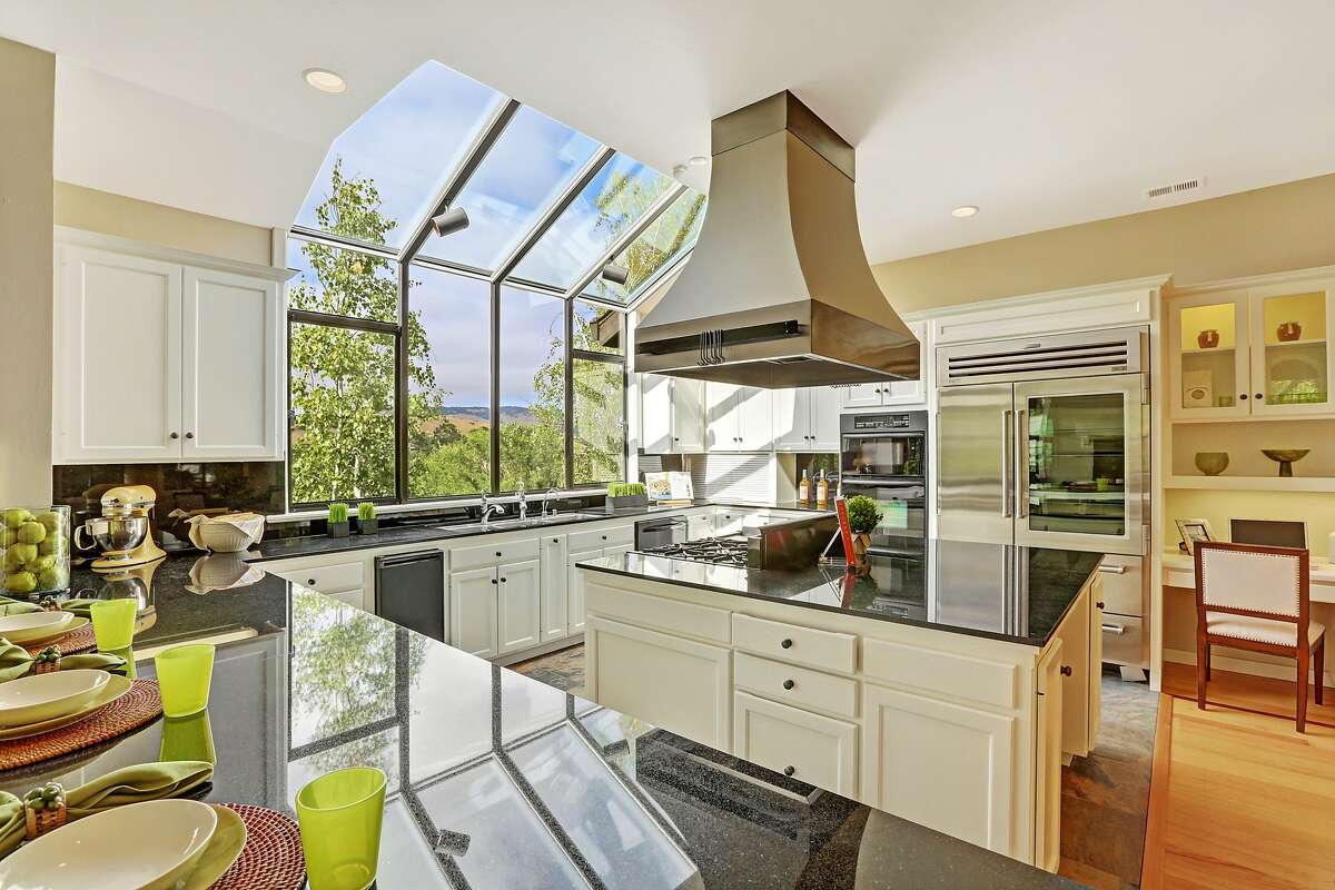 A wall of glass in the kitchen welcomes natural light into the workspace.