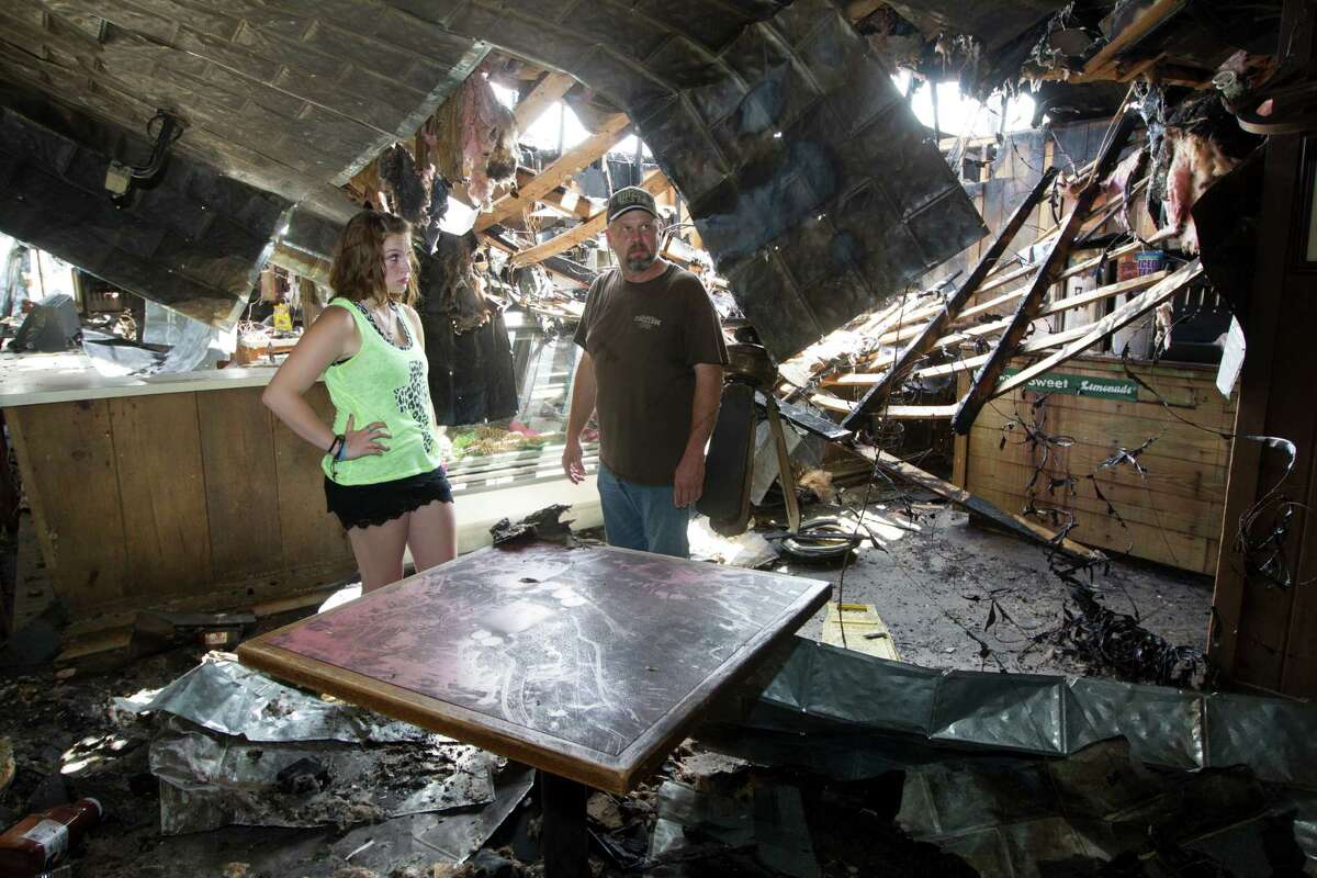 Michael Hinze and his daughter Libby, 17, survey the damage at his Bar-B-Que restaurant on Friday, Aug. 22, 2014, in Wharton. ( J. Patric Schneider / For the Chronicle )