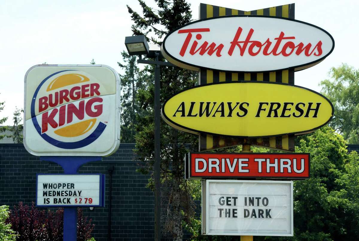 A Burger King sign and a Tim Hortons sign are displayed on St. Laurent Boulevard in Ottawa, Canada, on Monday, Aug. 25, 2014. Canada's iconic coffee chain, Tim Hortons, and Miami-based Burger King say they will join forces, but will operate as independent brands to form the world's third-largest quick service restaurant company. (AP Photo/The Canadian Press, Sean Kilpatrick)