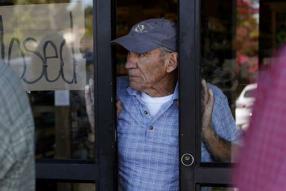 Browns Valley Market owner Larry Giovannoni looks out from his market which was badly damaged in the earthquake as he answers questions from the RMS team Tuesday August 26, 2014 in Napa, Calif. Risk Management Solutions (RMS) is a group of professionals that look at structural damage, liquefaction zones and interviews to determine the cost of the damage from an earthquake like the South Napa event.