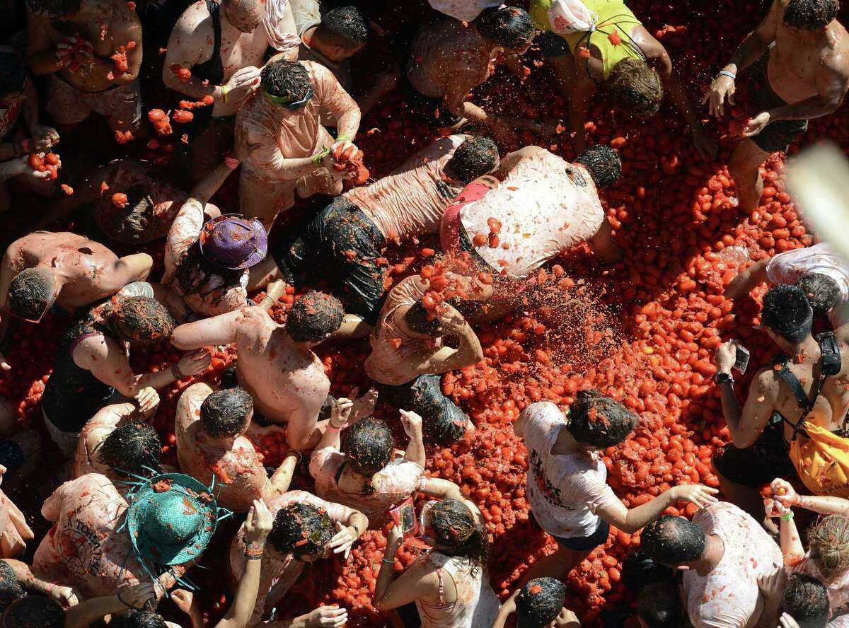 Revelers throw tomatoes while participating in the annual La Tomatina festival on Wednesday, Aug. 27, 2014, in Bunol district of Valencia, Spain.