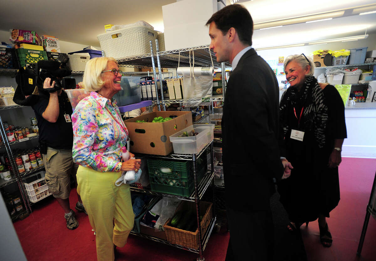 Person to Person Food Pantry volunteer Julie Thiele, left, of Stamford, talks with Congressman Jim Himes and Executive Director Cece Maher during Himes' visit to the non-profit as part of his 17 Towns in 17 Days Tour in Darien, Conn. on Thursday, August 21, 2014.