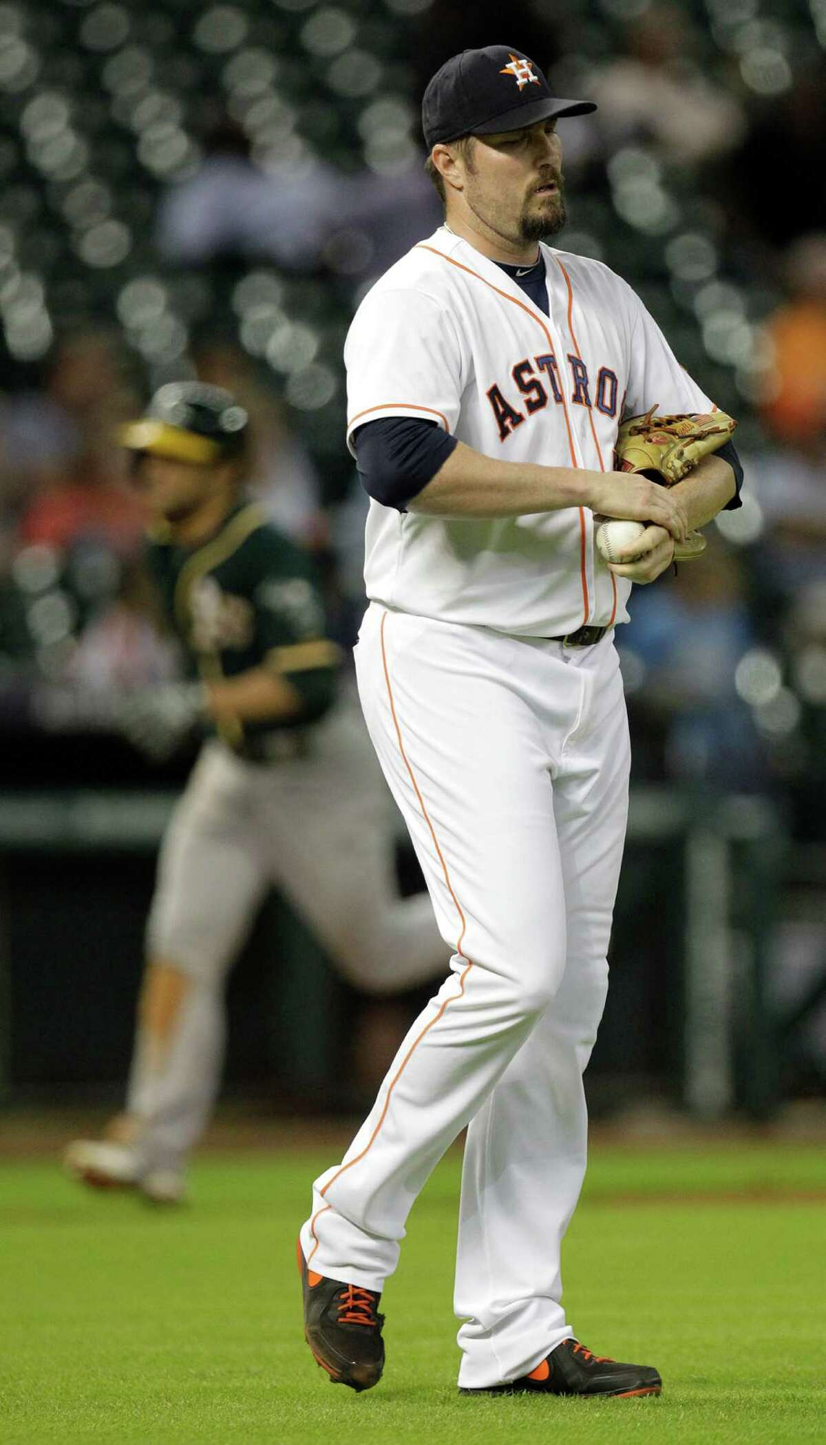 Houston Astros pitcher Chad Qualls walks to mound as Oakland Athletics Sam Fuld rounds the bases on his two run home run during the 9th inning at Minute Maid Park Wednesday, Aug. 27, 2014, in Houston. Coco Crisp also scored.