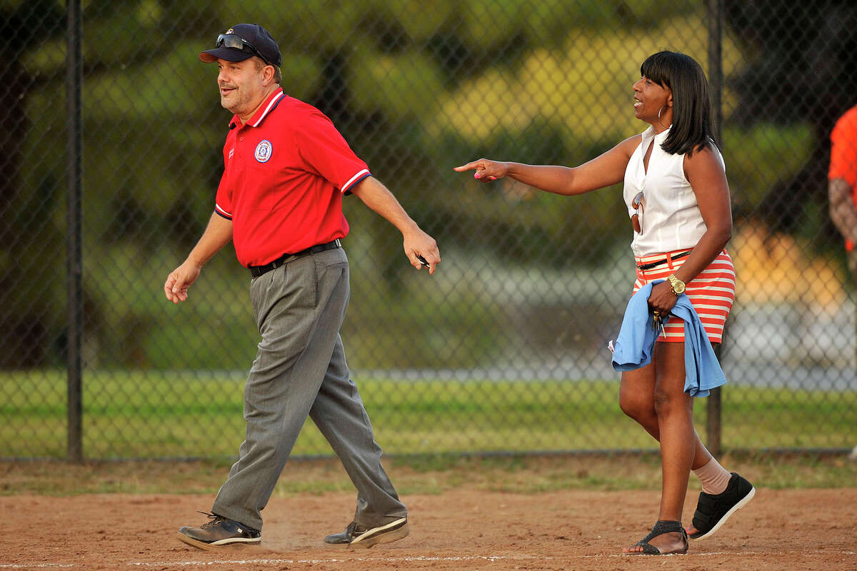 Board of Reps' third base coach Gloria DePina argues with umpire Charles Pia during the 31st annual Mayor's Team versus Board of Reps' Team softball game at Boccuzzi Park in Stamford, Conn., on Thursday, Aug. 28, 2014.