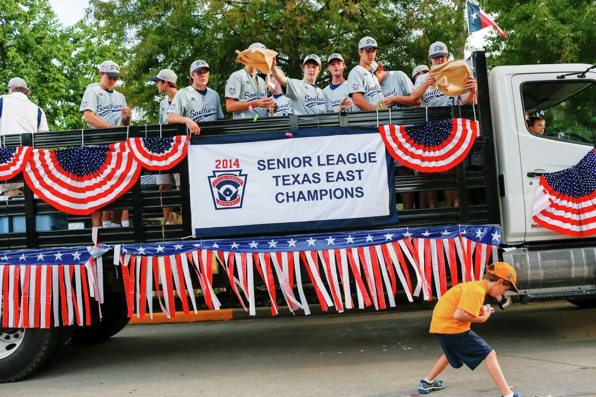 The West University Little League team tosses candy in a parade celebrating their Senior's world championship win, August 28, 2014 in Houston, TX.