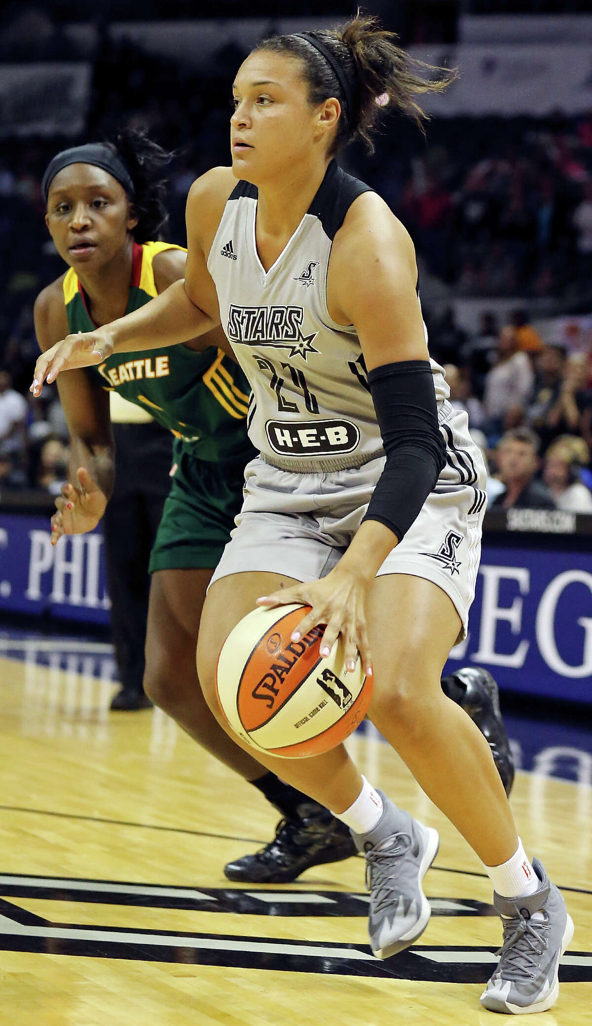 San Antonio Stars' Kayla McBride looks for room around Seattle Storm's Crystal Langhorne during first half action Friday July 11, 2014 at the AT&T Center.