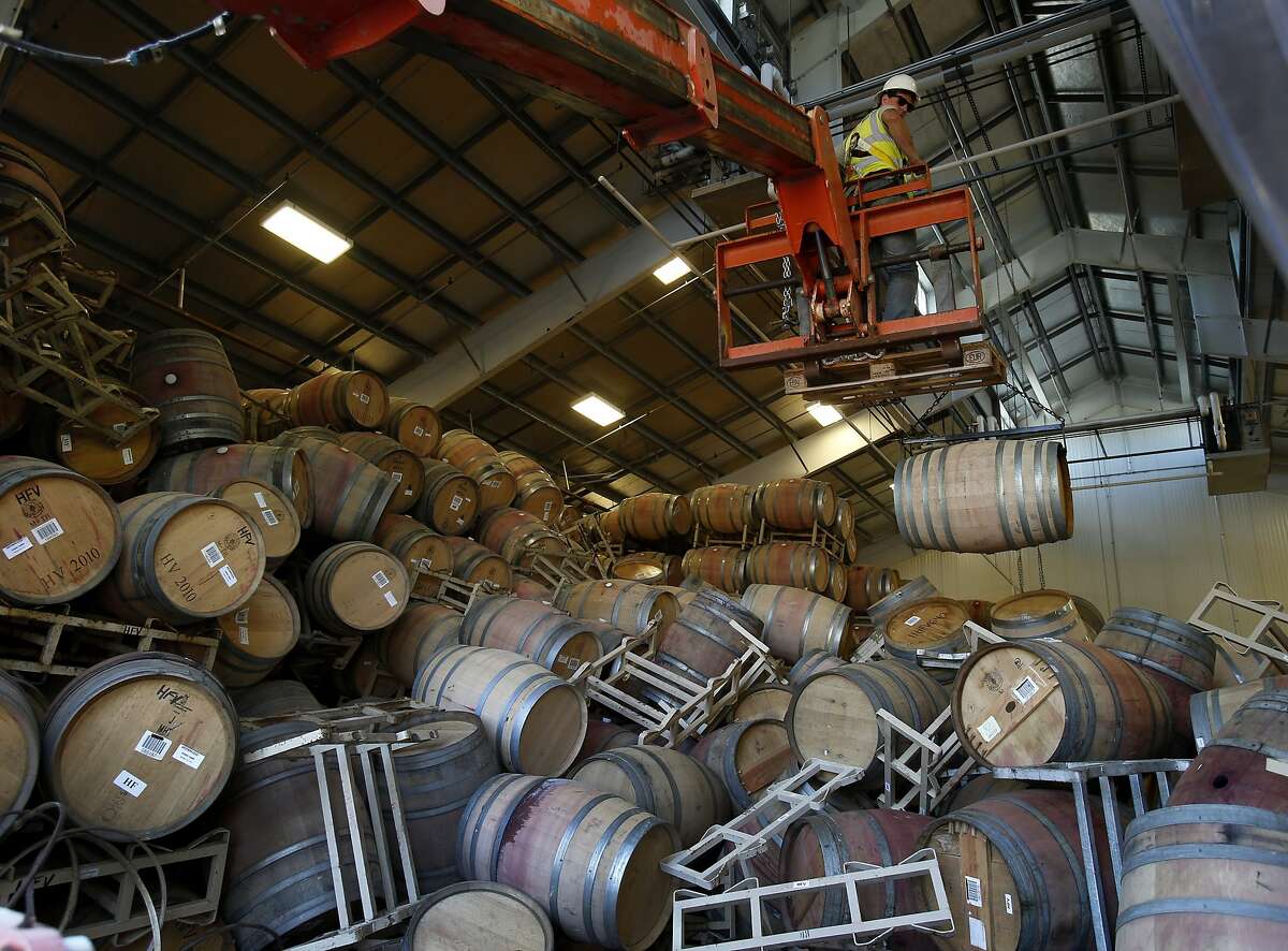 A work crew using a fork lift and a special harness started the process of bringing out hundreds of fallen wine barrels from Starmont Winery Wednesday August 27, 2014. Some southern Napa Valley wine makers were hit hard by the recent earthquake, but cleanup has been steady and 95 percent are now back in business.