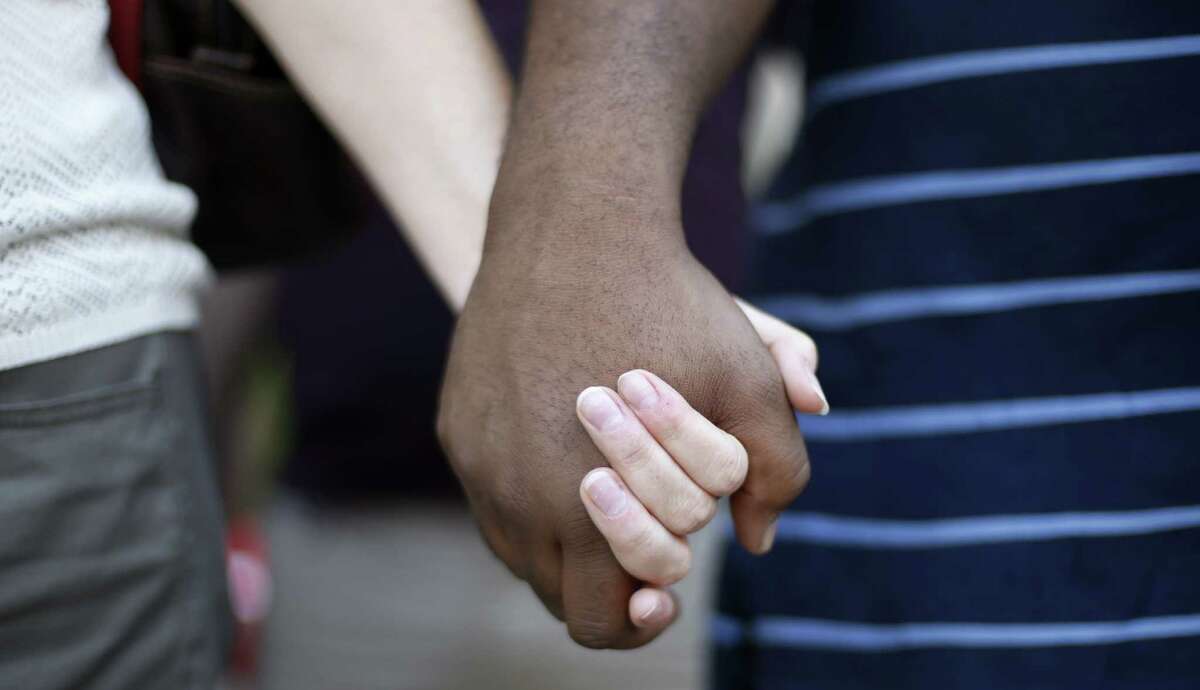 Participants hold hands at a prayer vigil for Michael Brown outside the McNamara Federal Building in Detroit Monday, Aug. 25, 2014. Brown, a