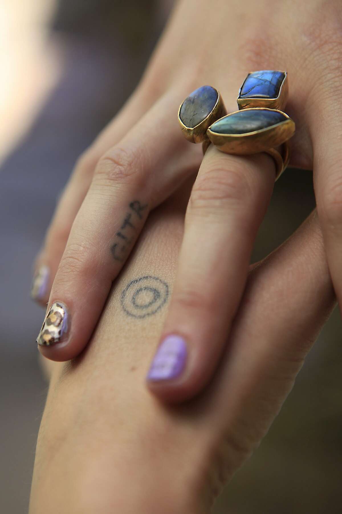 Hanna Cohen, friend of Stick & Poke creator Nicole West, shows her stick and poke tattoos on her hand and finger, at her home in San Francisco, CA, Saturday, August 30, 2014.