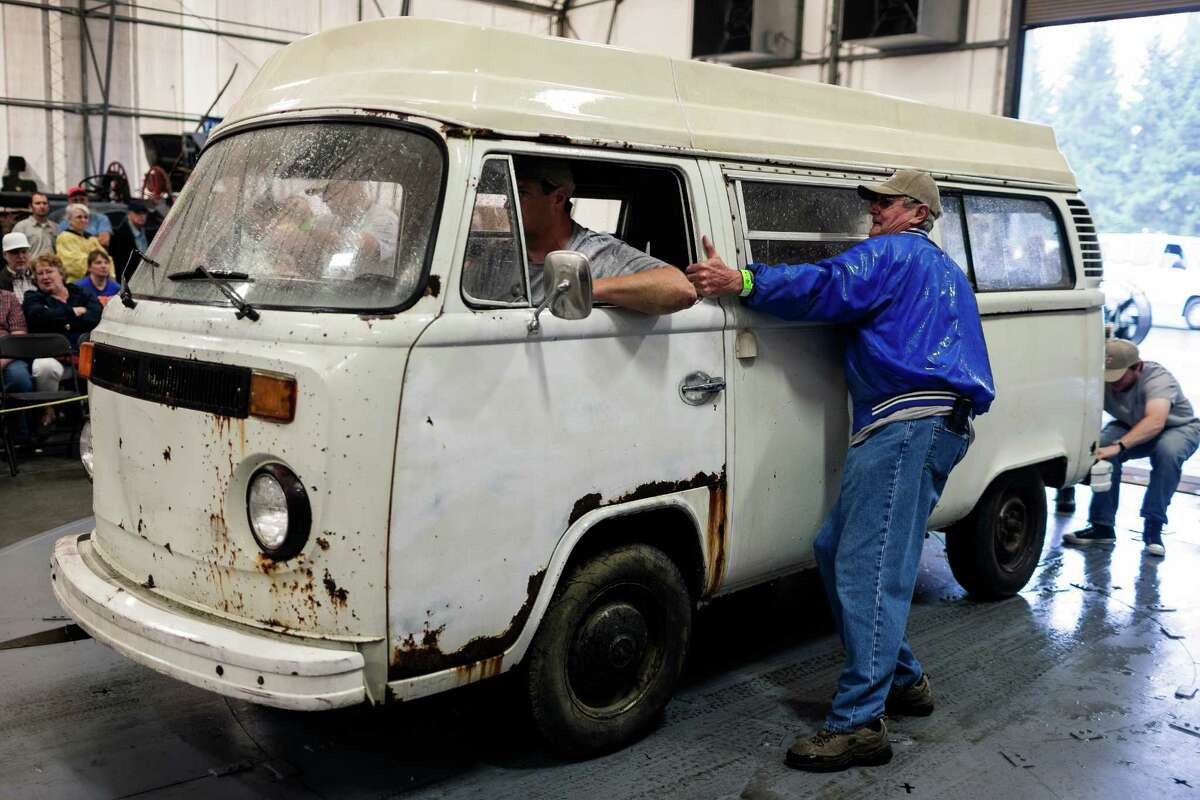 Struggling to control a Volkswagen bus with wet tires, an owner rolls in to auction off his vehicle.