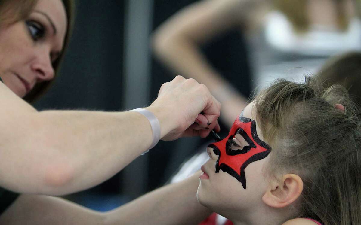 Jill Caldwell left, paints six-year-old Juliana Walker's face during the Amazing Houston Comic Con convention at George R Brown Convention Center Sunday, Aug. 31, 2014, in Houston.