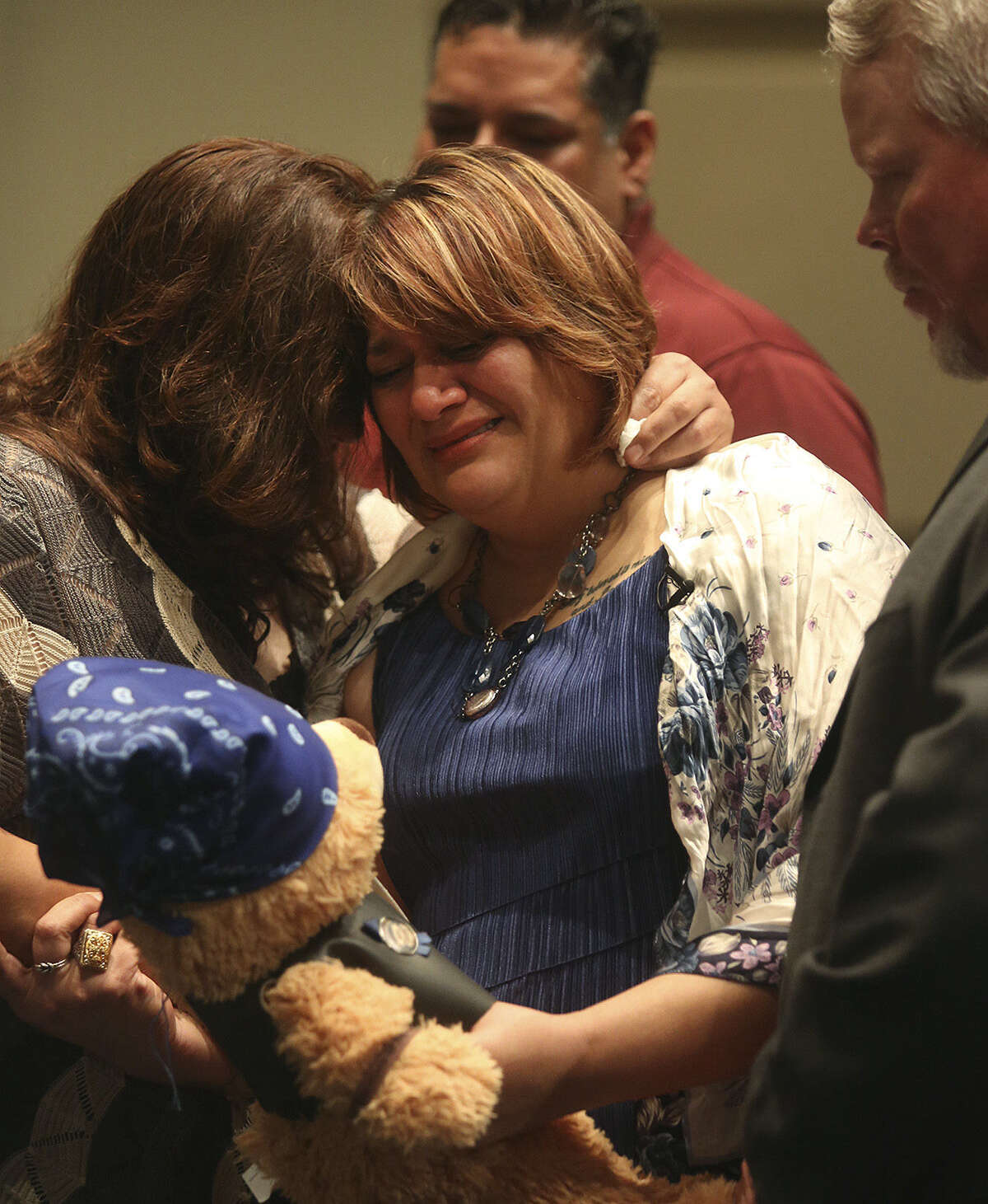 Pamela Allen (center) holds a bear given to her by the Guardians of the Children motorcycle group as she grieves with her sister Yvette Montejano (left), brother Samuel Espurvoa (back) and husband Tim Allen at the end of Baby Noel's funeral March 22.