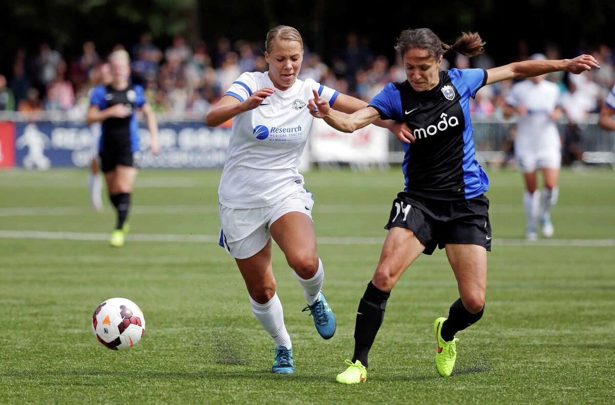 FC Kansas City's Merritt Mathias, left, and Seattle Reign FC's Stephanie Cox fight for the ball in the second half of the NWSL championship soccer match Sunday, Aug. 31, 2014, in Tukwila, Wash. Kansas City won 2-1.
