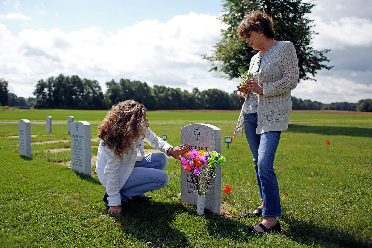 Michelle Campbell, left, mourns the death of her father, Robert Cesare, with her mother, Francesca Cesare, on Thursday, August 14, 2014 in Saratoga National Cemetery in Saratoga, N.Y. Robert Cesare died from three different forms of cancer due to exposure from Agent Orange used during the Vietnam War. (Tom Brenner/ Special to the Times Union)