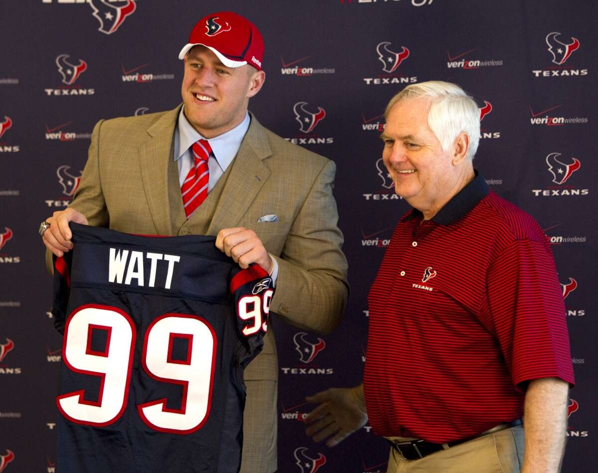 2011 Houston Texans first round draft pick J.J. Watt, a defensive end from Wisconsin, smiles as he holds his new Texans jersey while standing with defensive coordinator Wade Phillips during a news conference at Reliant Stadium Friday, April 29, 2011, in Houston. Watt was chosen by the Texans as the 11th pick in the first round of the NFL draft. ( Brett Coomer / Houston Chronicle )