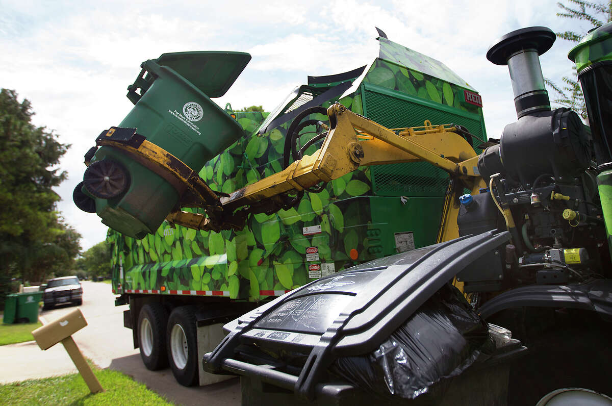 Ed Robinson picks up recycling along Woodmont Drive, Friday, Aug. 29, 2014, in Houston. 