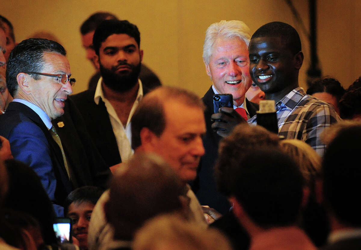 Former President Bill Clinton poses for a photo during a campaign visit in support of Gov. Dannel P. Malloy, left, at the Omini Hotel in New Haven, Conn. on Tuesday, September 2, 2014.