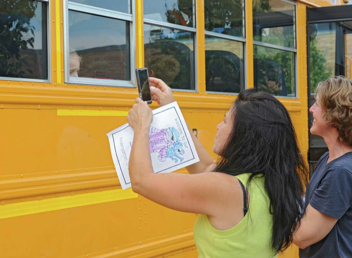 Micheline Geise of Wynantskill takes a photo of her son Lucas Nobre Geise, 5, as kindergarten students take a school bus for a test ride at Gardner-Dickinson School on Tuesday, Sept. 2, 2014 in North Greenbush, N.Y. Parents brought their kindergarten students to drop off school supplies, meet their teachers and take a quick bus ride. (Lori Van Buren / Times Union)