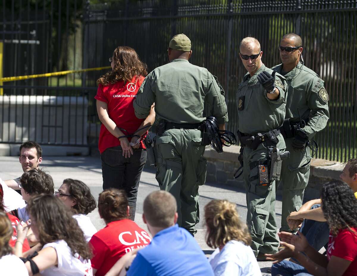 Demonstrators are arrested outside the White House in Washington on Thursday, Aug. 28, 2014 during a rally calling for President Barack Obama to stop deportations of migrants in the country illegally and to make a decision on how to provide relief for immigrant families. U.S. Park Police said 145 people were arrested. (AP Photo/Jose Luis Magana)