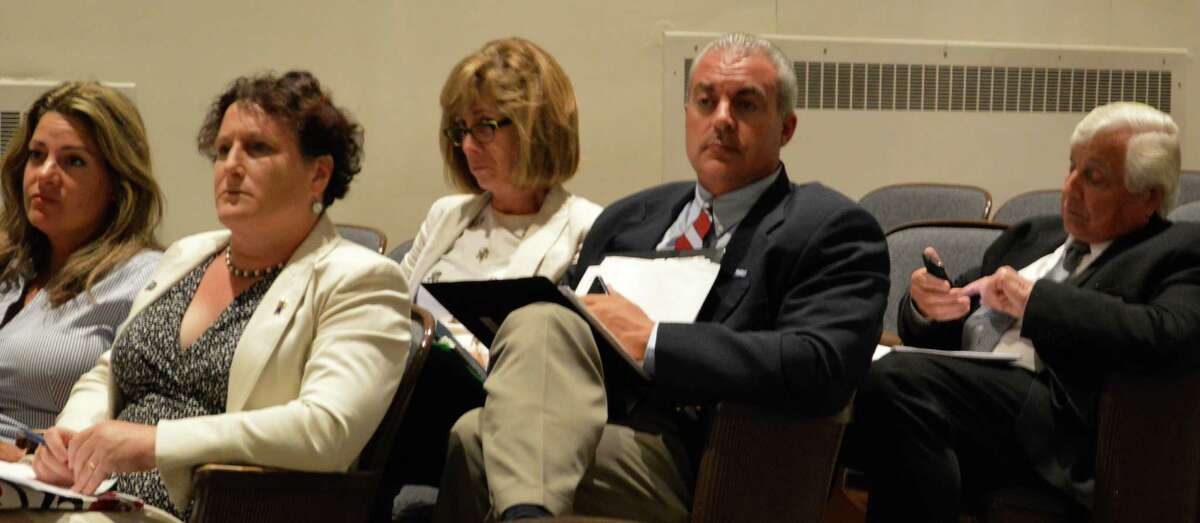 Superintendent of Schools Elliott Landon, at right, checks phone messages as other school officials listen to harsh criticism by the Board of Finance of unauthorized education budget transfers -- from left, Board of Education Vice Chairowman Jeannie Smith, Chairwoman Elaine Whitney, Marjorie Cion, school system director of human resources, and Elio Long, director of school business operations.