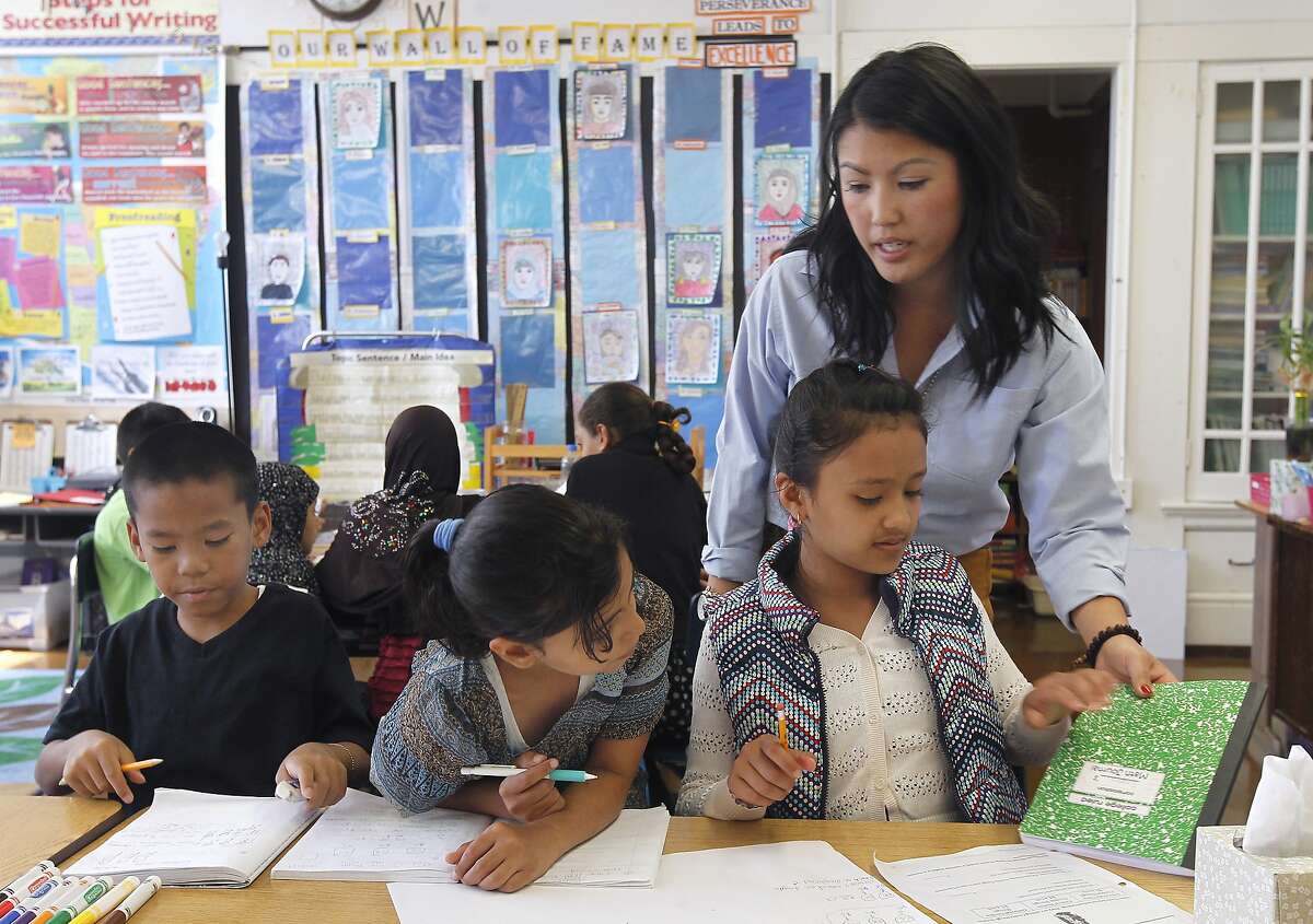 Teacher Mai-tien Nguyen helps 4th graders Lauren Salyphanh (left), Malak Hadwan (center) and Sneha Limbu with a math problem at Redding Elementary School in San Francisco, Calif. on Thursday, Sept. 4, 2014. Schools throughout the district are fully implementing the Common Core curriculum this year.