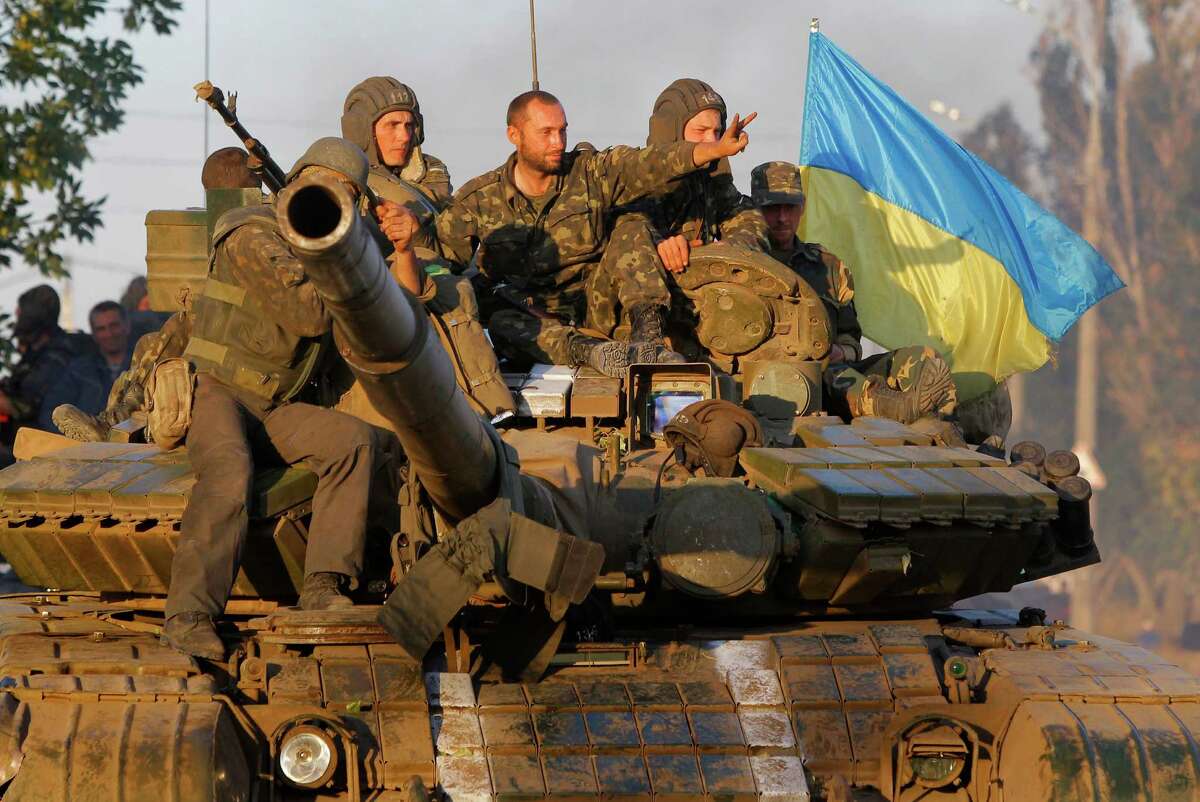 Soldiers of Ukrainian army ride on a tank in the port city of Mariupol, southeastern Ukraine, on Friday﻿. The Ukrainian president declared a cease-fire Friday to end nearly five months of fighting in the nation's east﻿.﻿