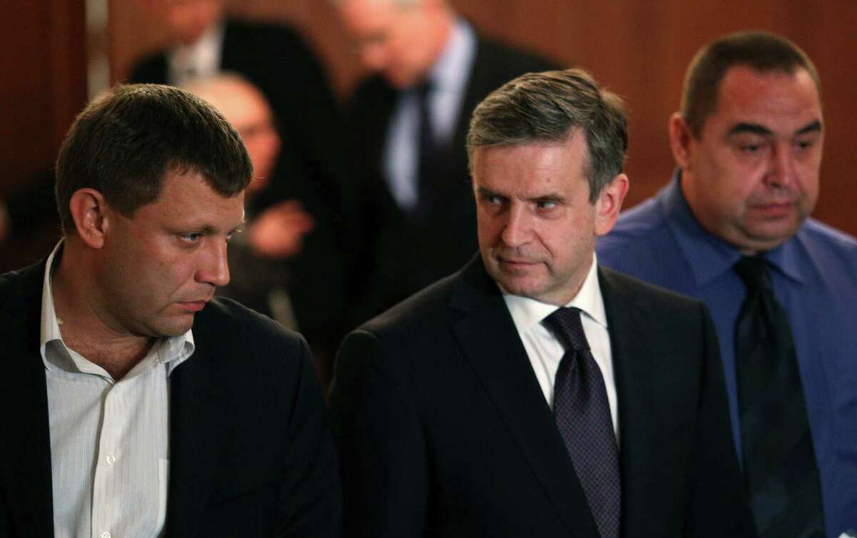 From left, Alexander Zakharchenko, the leader of pro-Russian rebels in Donetsk, Russian Ambassador to Ukraine Mikhail Zurabov and Igor Plotnitsky, the leader of pro-Russian rebels in the Luhansk region, meet with the media after talks on cease-fire in Ukraine in Minsk, Belarus, Friday, Sept. 5, 2014. The Ukrainian president declared a cease-fire Friday to end nearly five months of fighting in the nation's east after his representatives reached a deal with the Russian-backed rebels at peace talks in Minsk. (AP Photo)