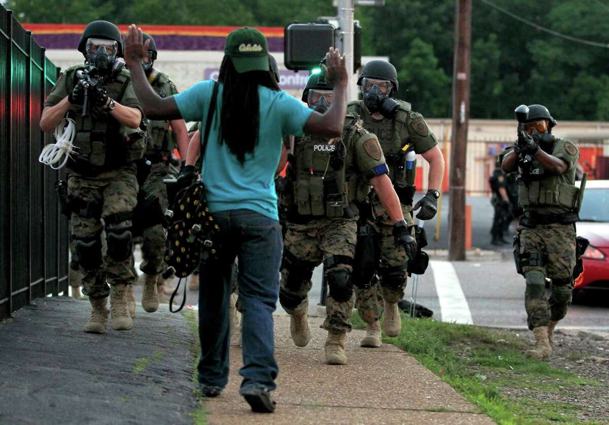 Police in riot gear arrest a man at gunpoint last month in Ferguson, Mo. - an image that some social media outlets might not allow.