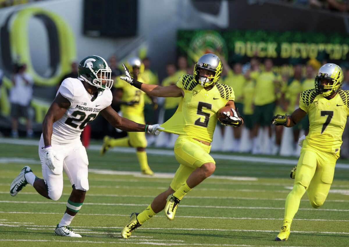 Oregon Ducks Devon Allen eludes tackle on his way to a second quarter touchdown against the Michigan State Spartans at Autzen Stadium, in Eugene, Oregon, Sat, Sept. 6, 2014. (AP Photo/The Oregonian, Thomas Booyd) MAGS OUT; TV OUT; LOCAL TELEVISION OUT; LOCAL INTERNET OUT; THE MERCURY OUT; WILLAMETTE WEEK OUT; PAMPLIN MEDIA GROUP OUT