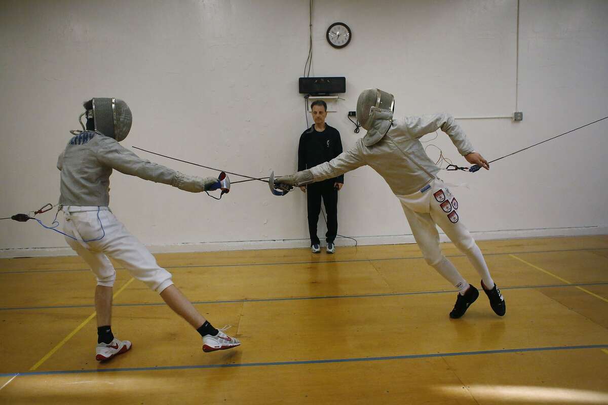 Robin Jeffry, 15, (left) tries to dodge a lung by Ethan Mullennix, 14, at Halberstadt Fencers' Club in San Francisco, Calif.