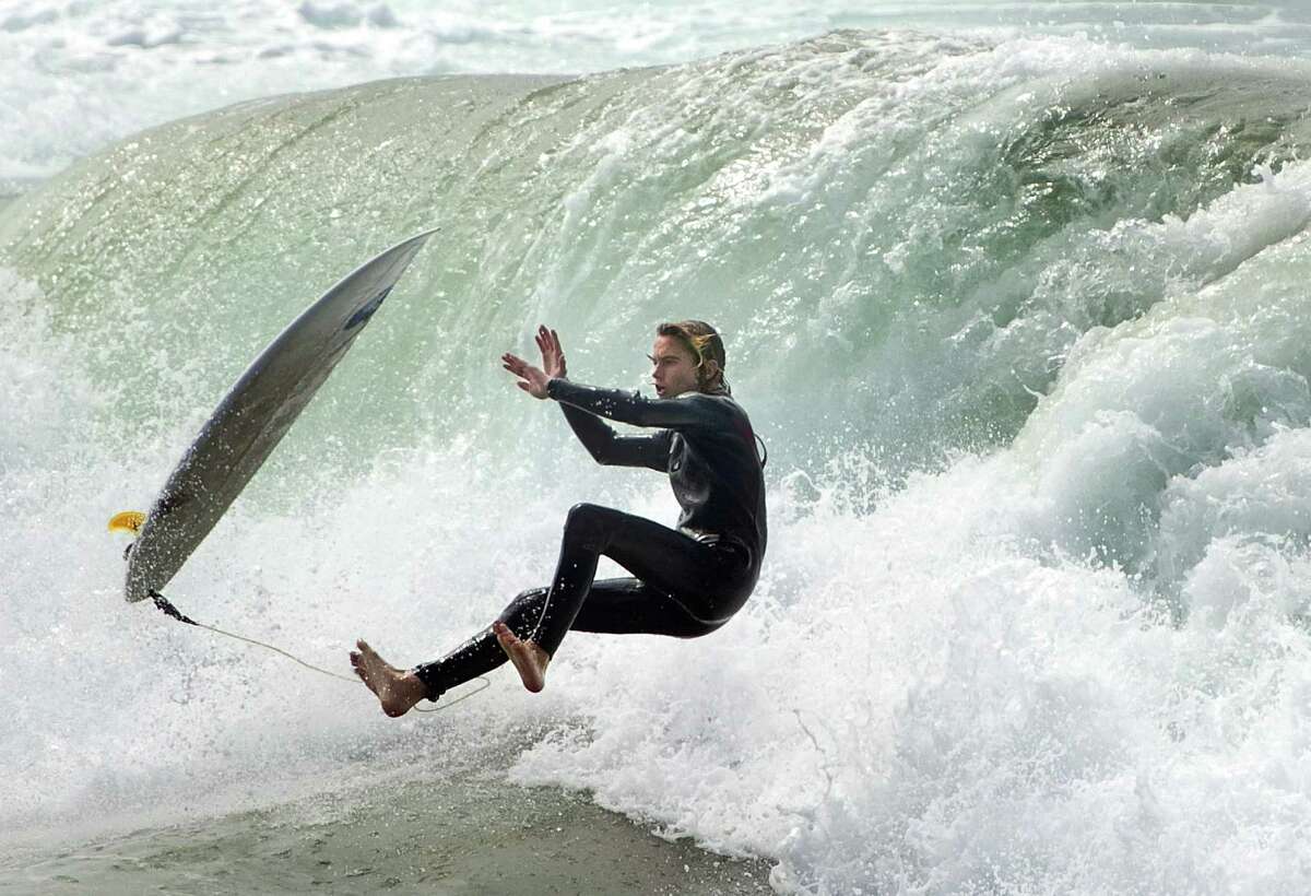 A surfer loses his board as he rides a wave in Huntington Beach, Calif., on Sunday, Sept. 7, 2014. Hurricane Norbert slumped to tropical storm force off of Mexico's Baja California peninsula on Sunday after pounding fishing villages and damaging more than 1,000 homes while kicking up dangerous surf farther north along the California coast.