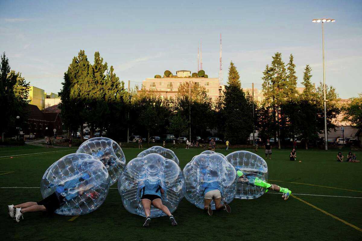 Encased in bouncy, blue orbs, teams huddled up as best their rotund shape allowed them before a match at Seattle's first "Bubble Futbol" - or soccer - tournament Sunday, September 7, 2014, at Cal Anderson Park in Capitol Hill in Seattle, Washington. The unlikely sport originated in Europe and is quickly sweeping the U.S., with a recent spotlight on ?’The Tonight Show with Jimmy Fallon.?“ The event was put on by Seattle-local nonprofit "The World is Fun" as a celebration of the organization's fifth anniversary.
