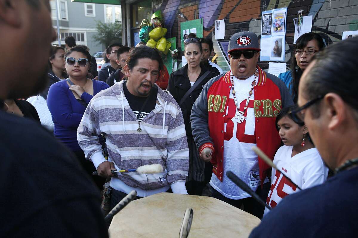 Luis Chavez, left, and George Galvis, right, drum with others as they sing a traditional song to honor Williams' Lakota heritage during a vigil held in honor of Rashawn Williams, 14, at the corner where he was stabbed to death last week on 26th and Folsom Sept. 7, 2014 in San Francisco, Calif.