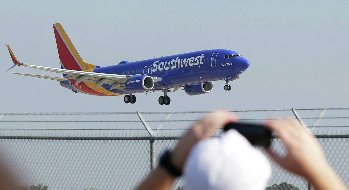 A Southwest Airlines plane with a new paint job flies over Love Field Monday, Sept. 8, 2014, in Dallas. The change comes in a year during which 43-year-old Southwest has begun international flights, expanded in New York and Washington, and is freed from longtime government limits on its Dallas schedule. (AP Photo/LM Otero)