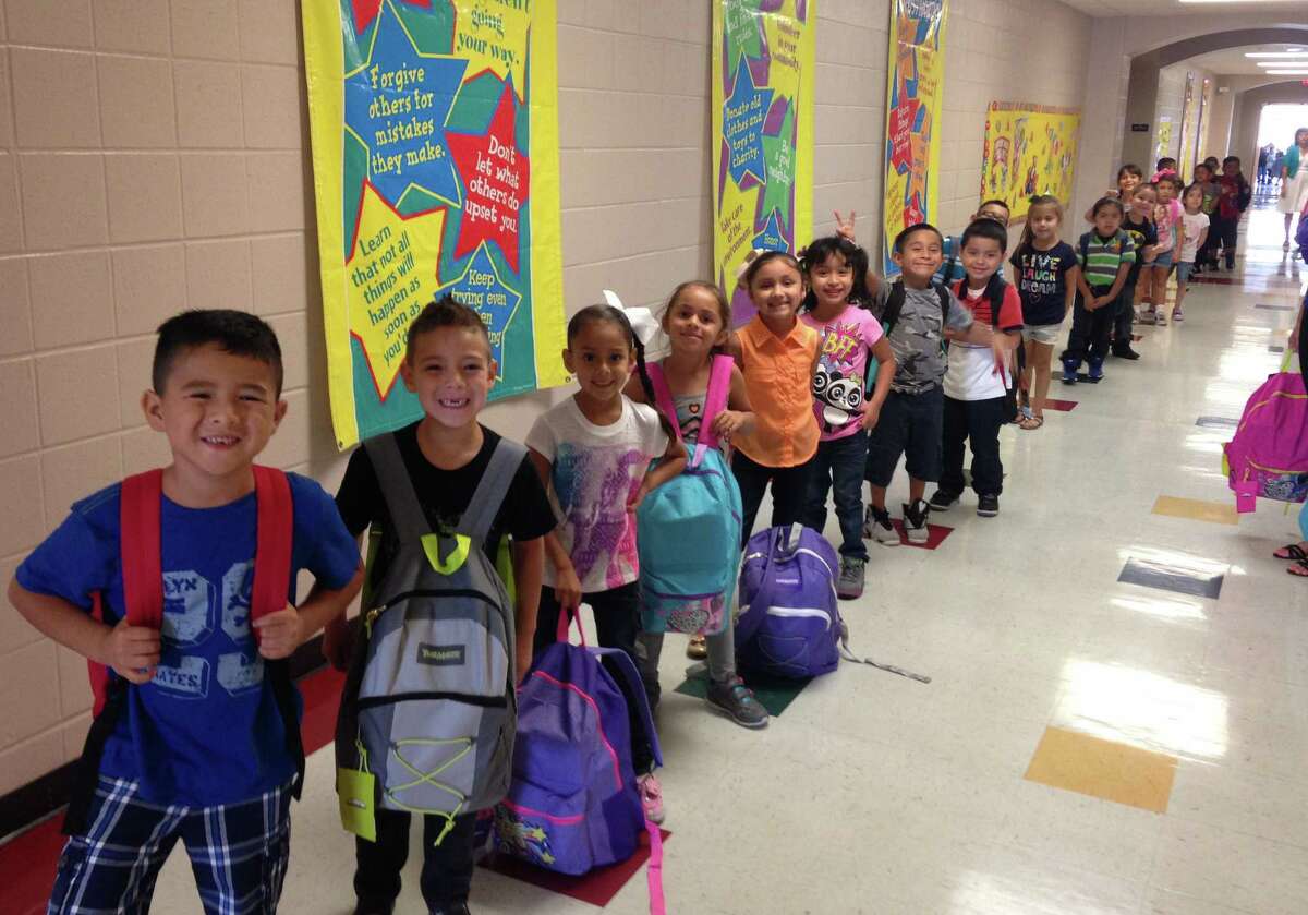 Students at HISD's Gilbert Elementary display their new backpacks stuffed with school supplies. The gear was donated by Nicha's Mexican Restaurant, which gave 200 backpacks, twice what they gave last year.