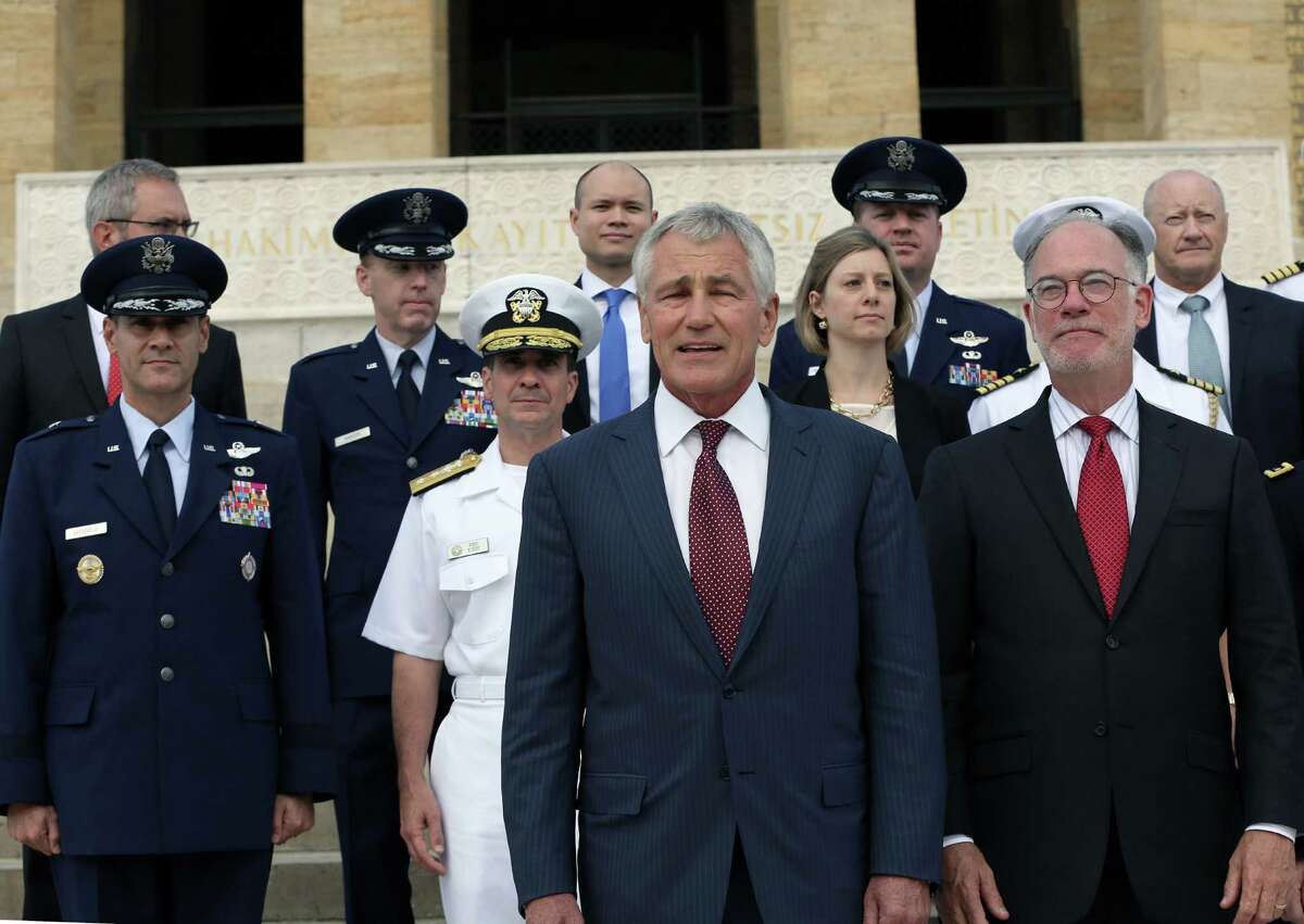 U.S. Defense Secretary Chuck Hagel, front, poses for cameras with his staff as he visits the mausoleum of Mustafa Kemal Ataturk, the founder of modern Turkey, in Ankara, Turkey, Monday, Sept. 8, 2014. Hagel is in Turkey for talks with Turkish leaders.(AP Photo/Burhan Ozbilici)