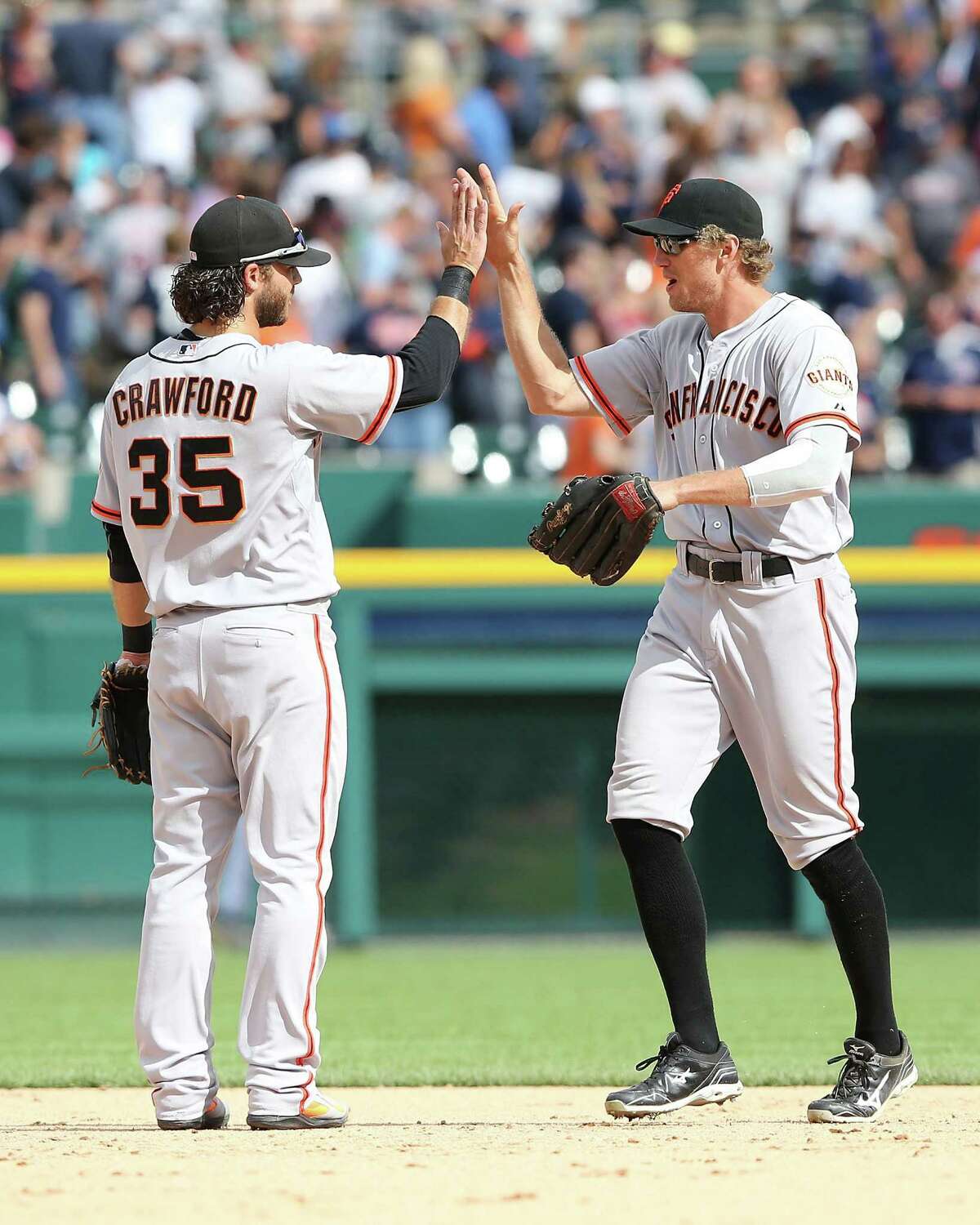 DETROIT, MI - SEPTEMBER 06: Brandon Crawford #35 and Hunter Pence #8 of the San Francisco Giants celebrate a win over the Detroit Tigers at Comerica Park on September 6, 2014 in Detroit, Michigan. The Giants defeated the Tigers 5-4. (Photo by Leon Halip/Getty Images)