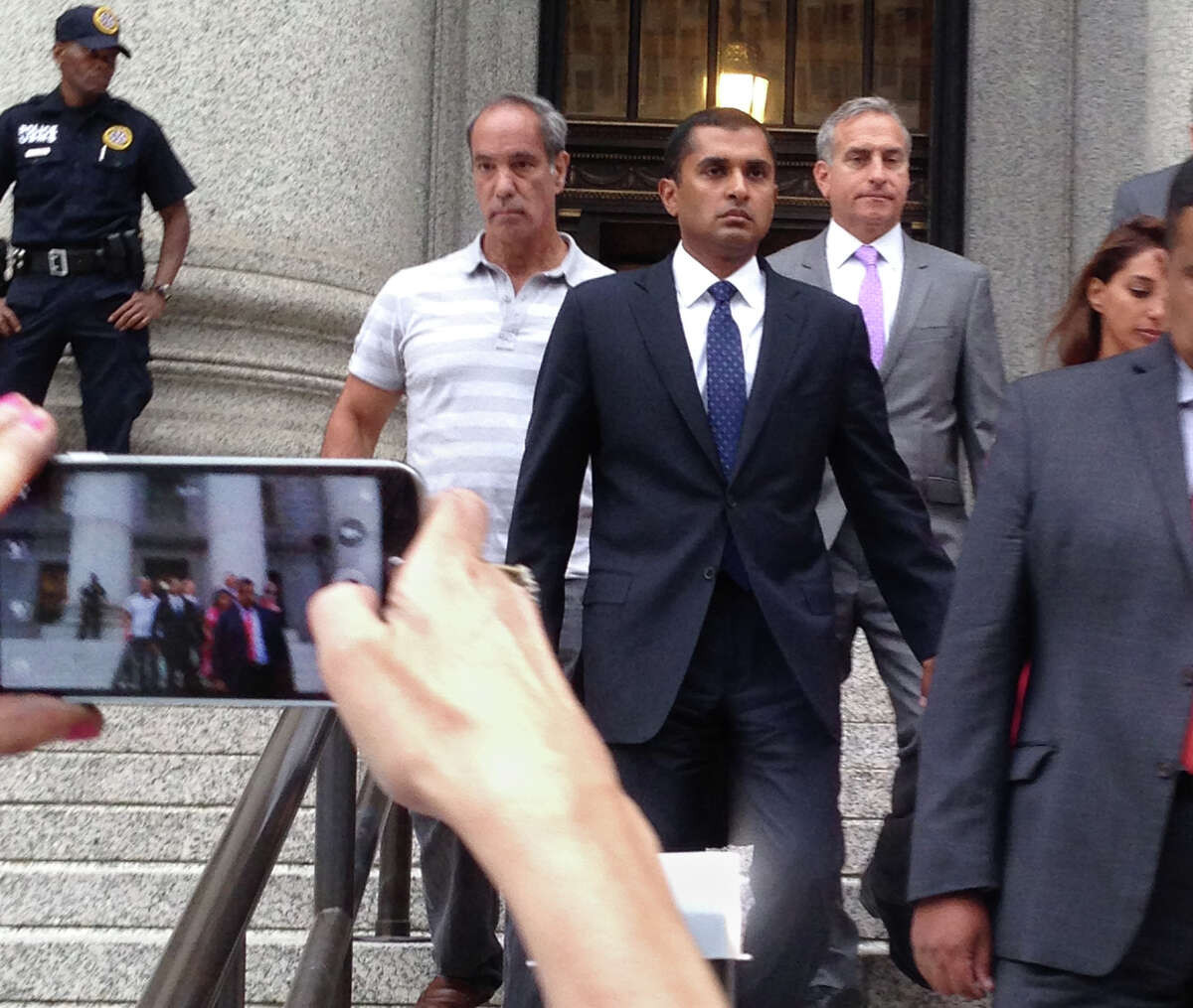 Mathew Martoma, center, leaves court Monday after being sentenced to nine years in an inside trading case. He had worked for SAC Capital Advisors.