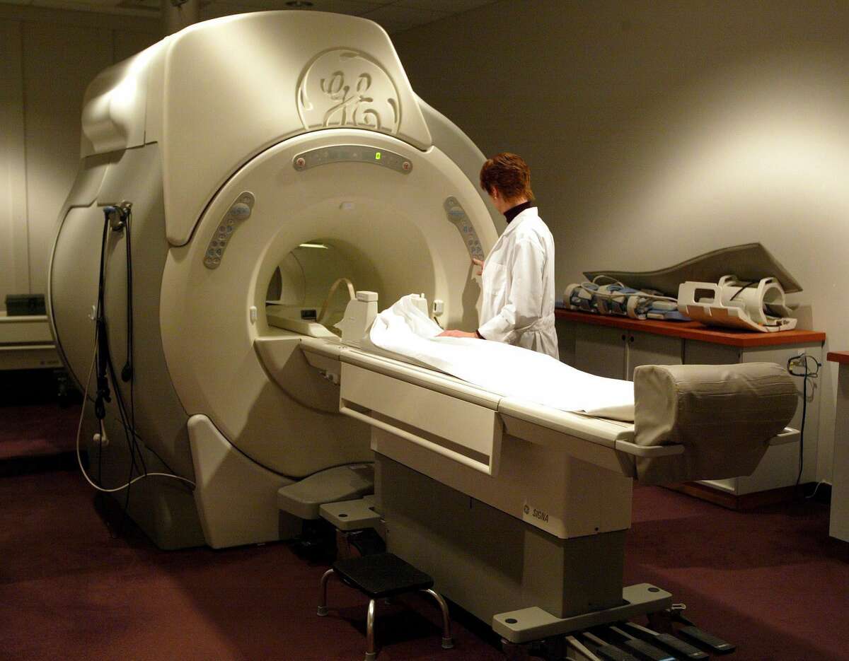 FILE - In this Jan. 12, 2005 file photo, a technician operates a General Electric MRI machine at a private clinic in Calgary, Alberta. The sale of the company's appliance division, announced Monday, Sept. 8, 2014, is the latest in a long string of moves by GE to shift its focus away from consumers and toward the manufacturing of giant, complex industrial machines such as aircraft engines, locomotives, gas-fired turbines and medical imaging equipment. (AP Photo/The Canadian Press, Jeff McIntosh, File)