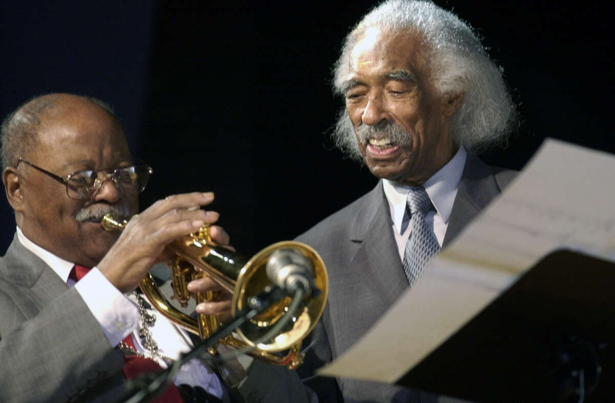 FILE - In tis Feb. 28, 2003 file photo, jazz trumpeter and former Navy band member Clark Terry, left, plays under the watchful eye of guest conductor Gerald Wilson, also a former Navy band member, at a concert at the Great Lakes Naval Training Center in Great Lakes, Ill. Wilson, the dynamic jazz big band leader, composer and arranger whose career spanned more than 75 years, died Monday, Sept. 8, 2014. He was 96. (AP Photo/Brian Kersey, File)