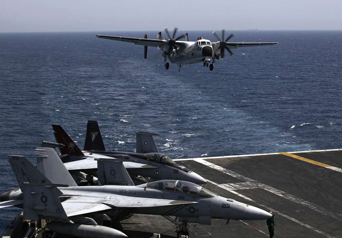 FILE - In this Monday, Aug. 11, 2014 file photo, a U.S. military plane lands on the U.S. Navy aircraft carrier USS George H.W. Bush, in the Persian Gulf. As the United States looks to stitch together a coalition to tackle the extremist Islamic State group, the Obama administration will have to overcome the reluctance of Mideast allies who are deeply frustrated with a White House that they believe has been naive, fickle and weak on Syria's civil war. (AP Photo/Hasan Jamali, File)