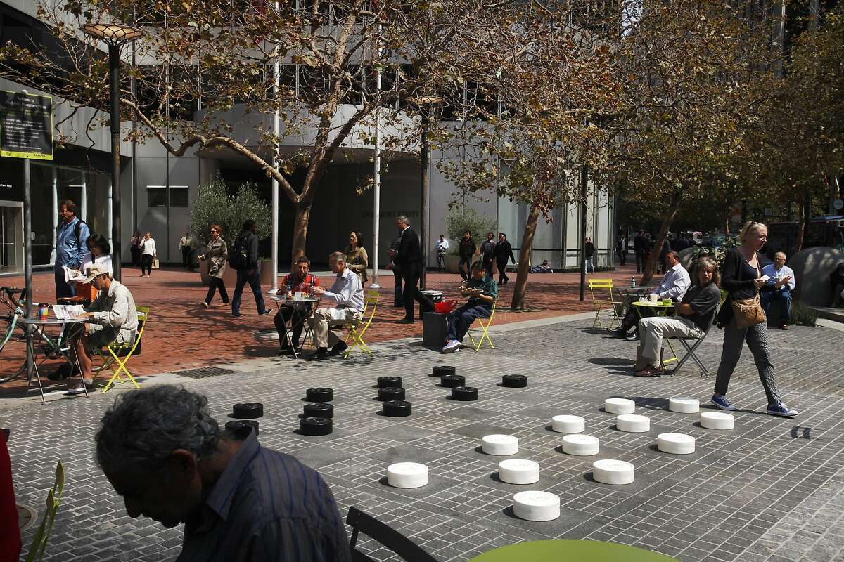People listen to music as they eat lunch and pass through the recently refinished Mechanics Plaza Sept. 9, 2014 in San Francisco, Calif. Tables and chairs were added to the space as well as a large checkers/chess board design on the ground. The band Dos Gardenias played music at noon as part of the People in the Plazas Summer Music Festival.