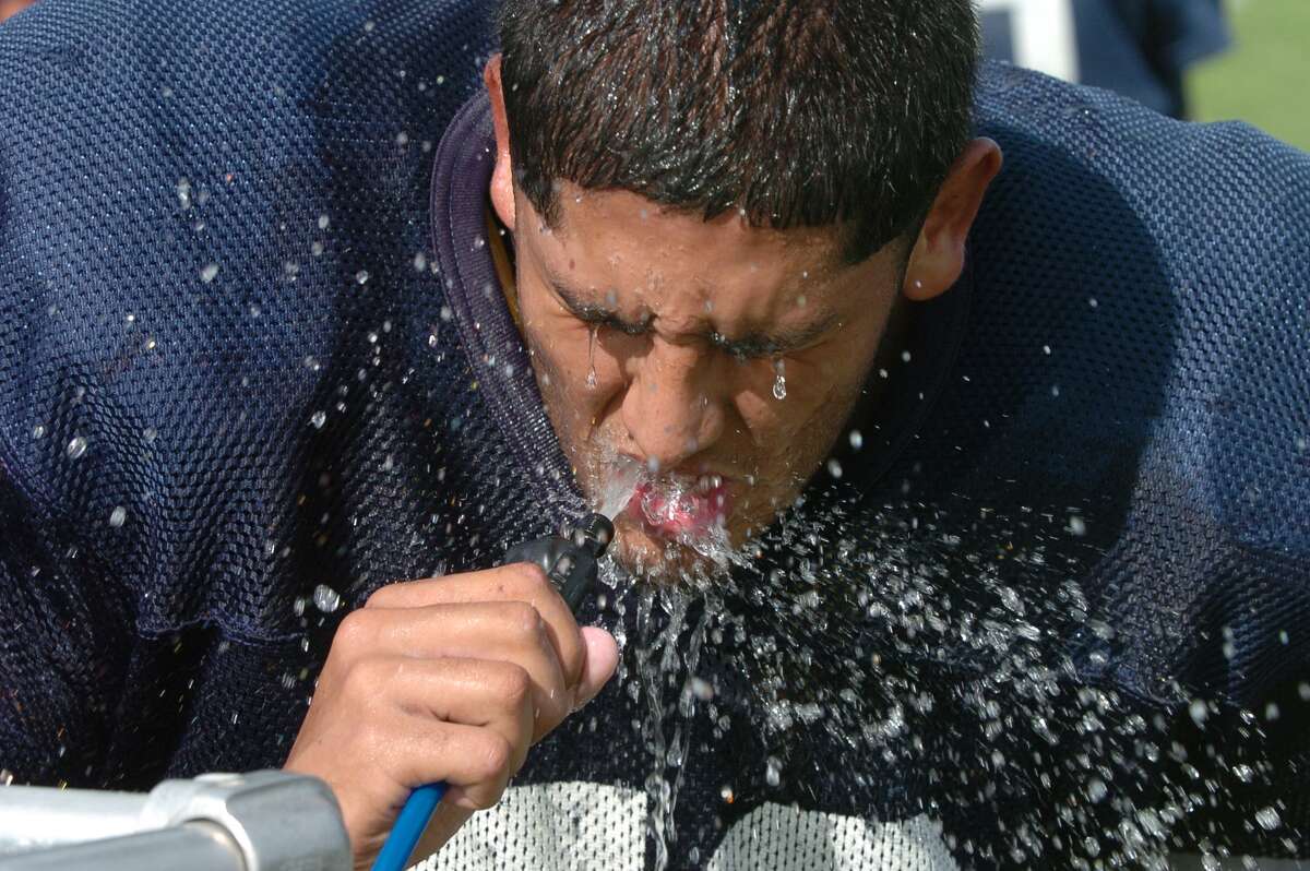 Cy Ranch football team practiced, 9-4-2014. Albert Santana took advantage of the cool water in the ninety degree temperature.