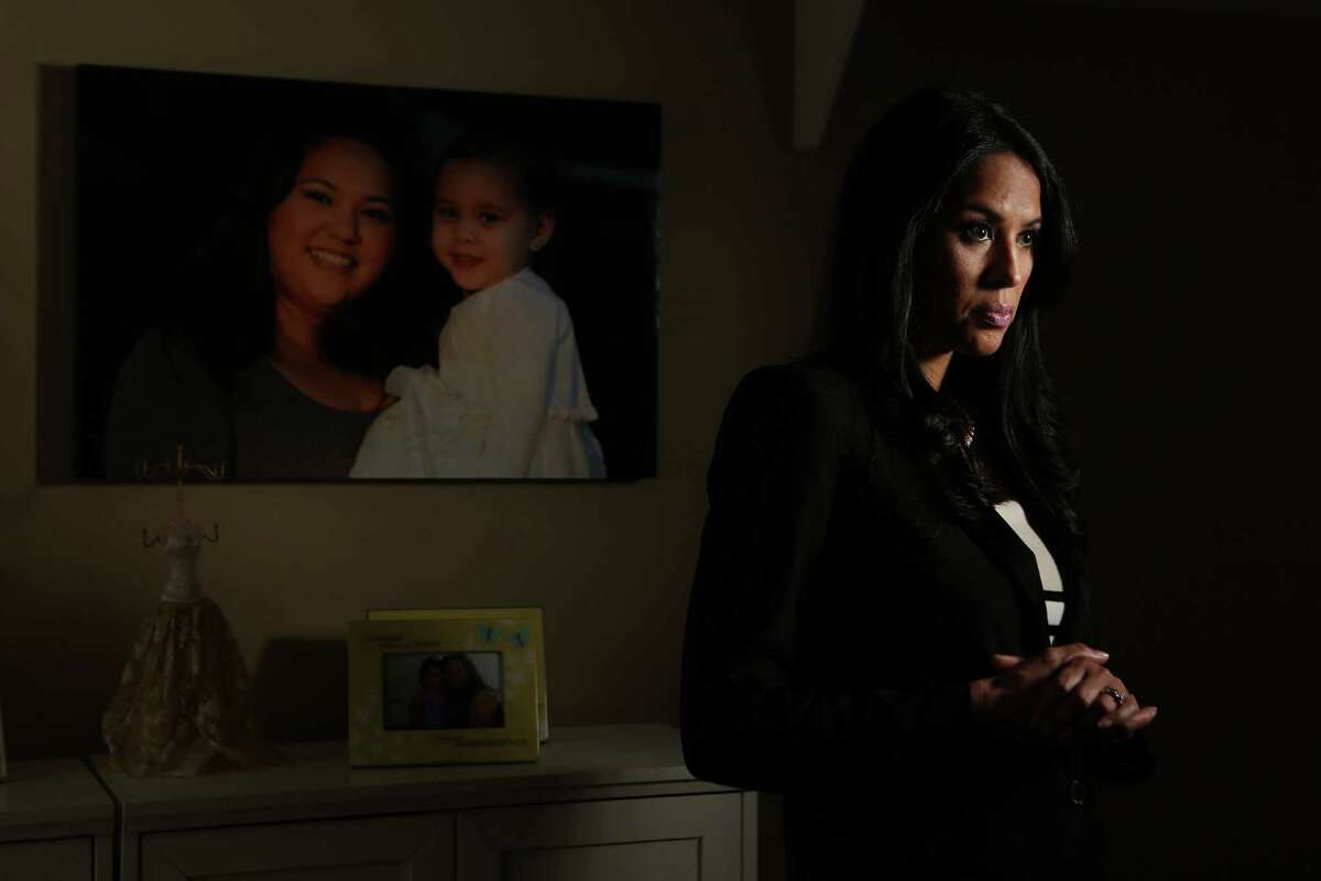 Lisa Forsythe stands next to a photograph of her sister holding her daughter which she has primary custody of her niece after her parents died two years ago on Thursday, Sept. 4, 2014, in Houston. Linda Alton, was killed by her ex-boyfriend in May 2012, five months after this judge denied her protective orders application. He shot her several times in front of their 2-year-old daughter before turning the gun on himself. ( Mayra Beltran / Houston Chronicle )
