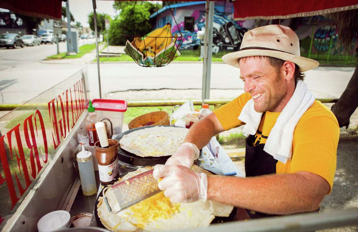 FOR CHRON 100 RESTAURANT REVIEW. DO NOT USE FOR ANYTHING ELSE WITHOUT A PHOTO EDITOR'S PERMISSION. THANKS. Sean Carroll, owner of Melange Creperie, jokes with customers as he shreds cheese on a crepe on his crepe cart, photographed, Sunday, July 20, 2014, in Houston. ( Nick de la Torre )