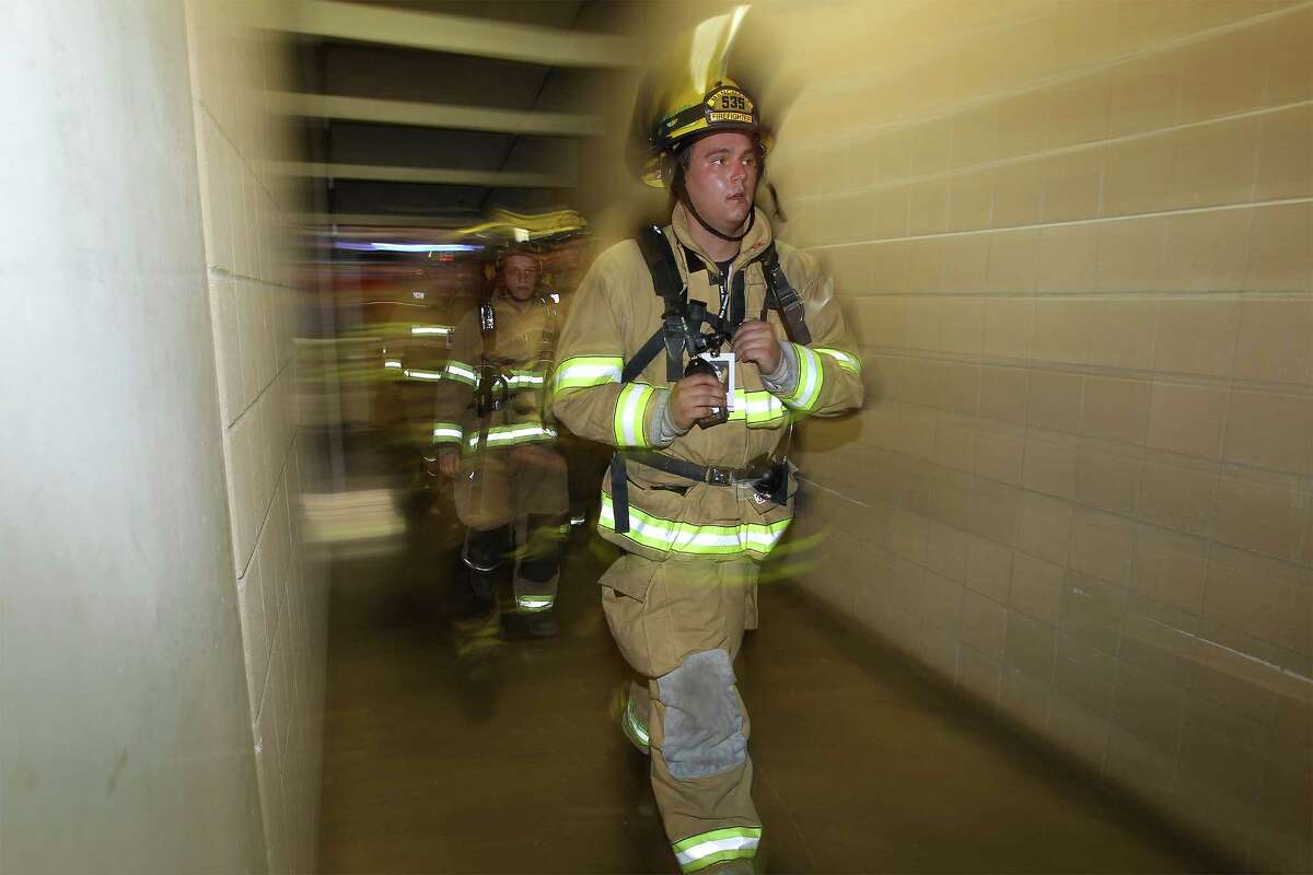 Firefighters exit a tunnel inside the Alamodome during the San Antonio 110 9/11 Memorial Climb at the Alamodome on Thursday, Sept. 11, 2014. Hundreds of first responders and civilians gathered to take part in the event to pay tribute to the fallen firefighters from Sept. 11, 2001. Each participating first responder carried the face and name of firefighter that perished 13 years ago in New York City. Many wore bunker gear and breathing apparatus that added up to additional pounds as a tribute during their climb. At the end of the climb, a name tag of the fallen firefighter was placed on a 9/11 memorial, their name called out and a bell was rung.
